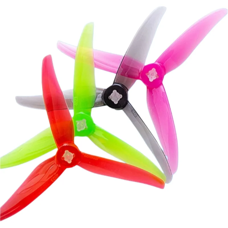 Hélices de drone vertes et rouges disposées en croix, prêtes à être installées sur votre quadricoptère.