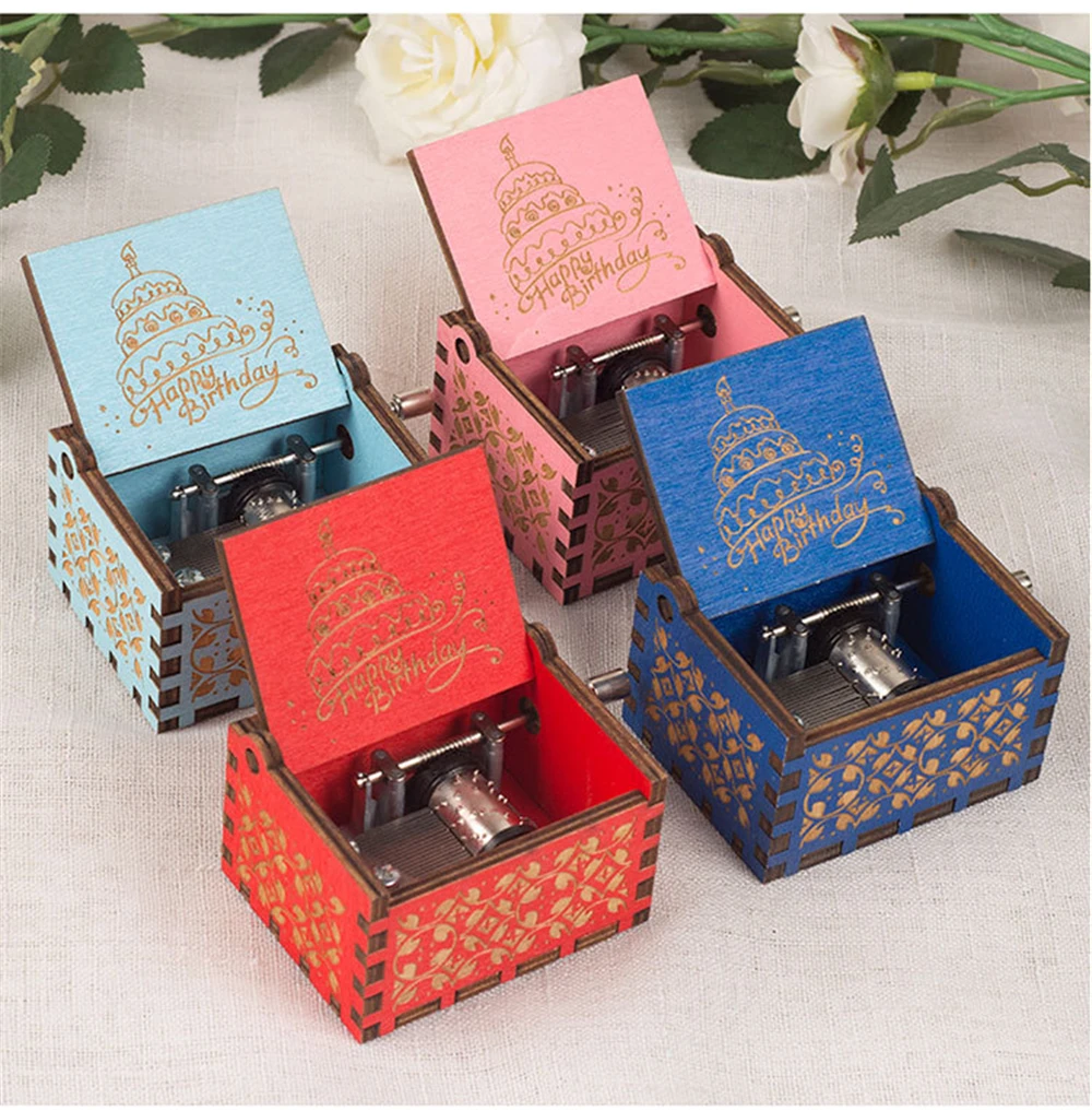 The charming Happy Birthday Music Box is available in four colors: blue, red, pink, and light blue. Each wooden box features a decorative design and an engraving that reads "Happy Birthday," with an open lid that reveals the mechanism inside. These delightful music boxes make the perfect birthday gift.