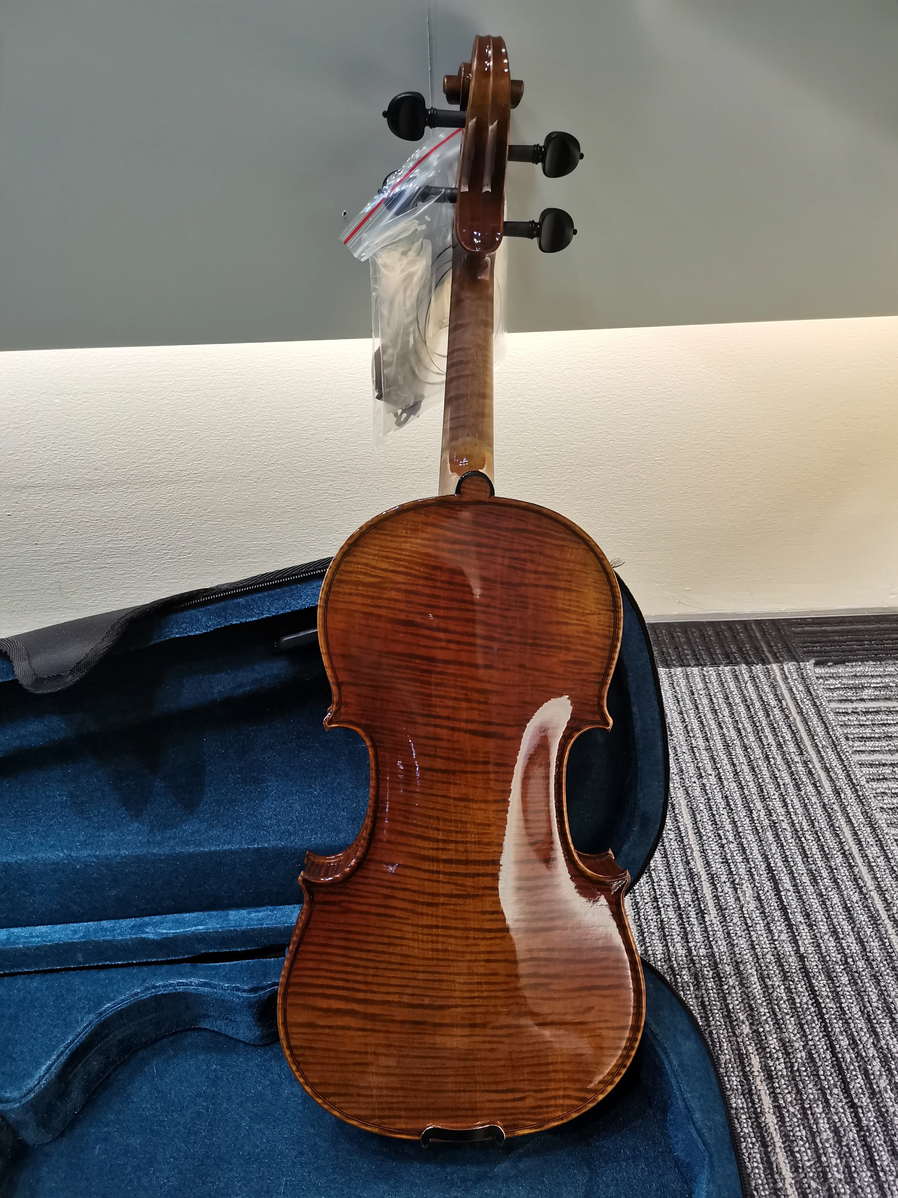 4/4 high-end handmade Italian violin with ebony flat knobs and vintage lacquer, featuring strings, bow, and case.