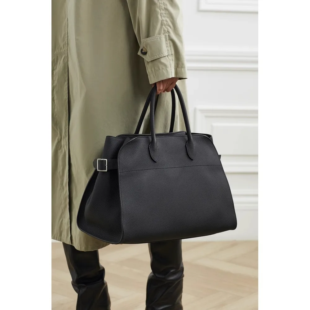 he Leather Tote bag is made of cowhide and designed for commuters, featuring a textured travel bag for women.
