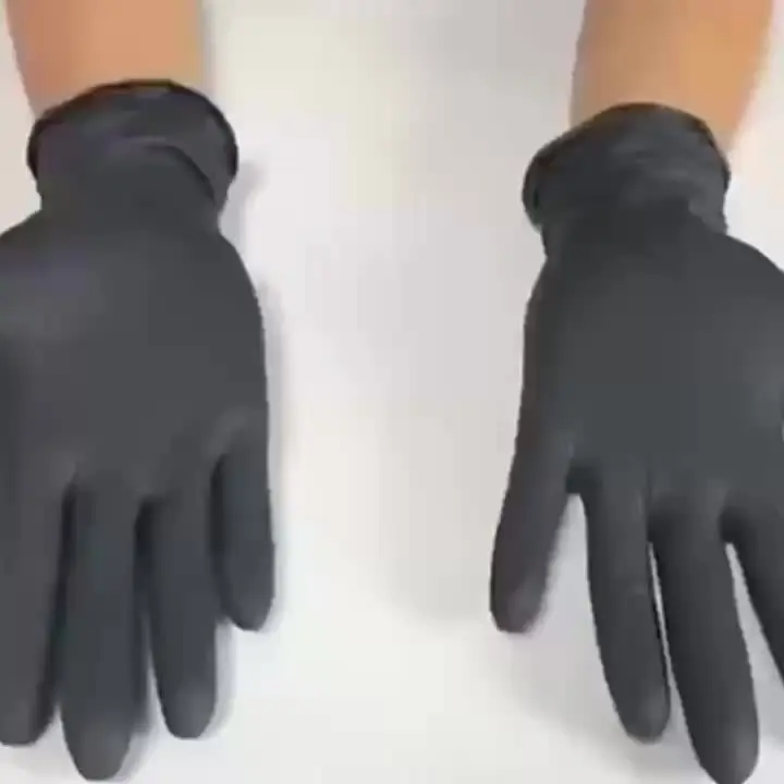 Mains portant des gants jetables noirs manipulant un objet sanitaire.