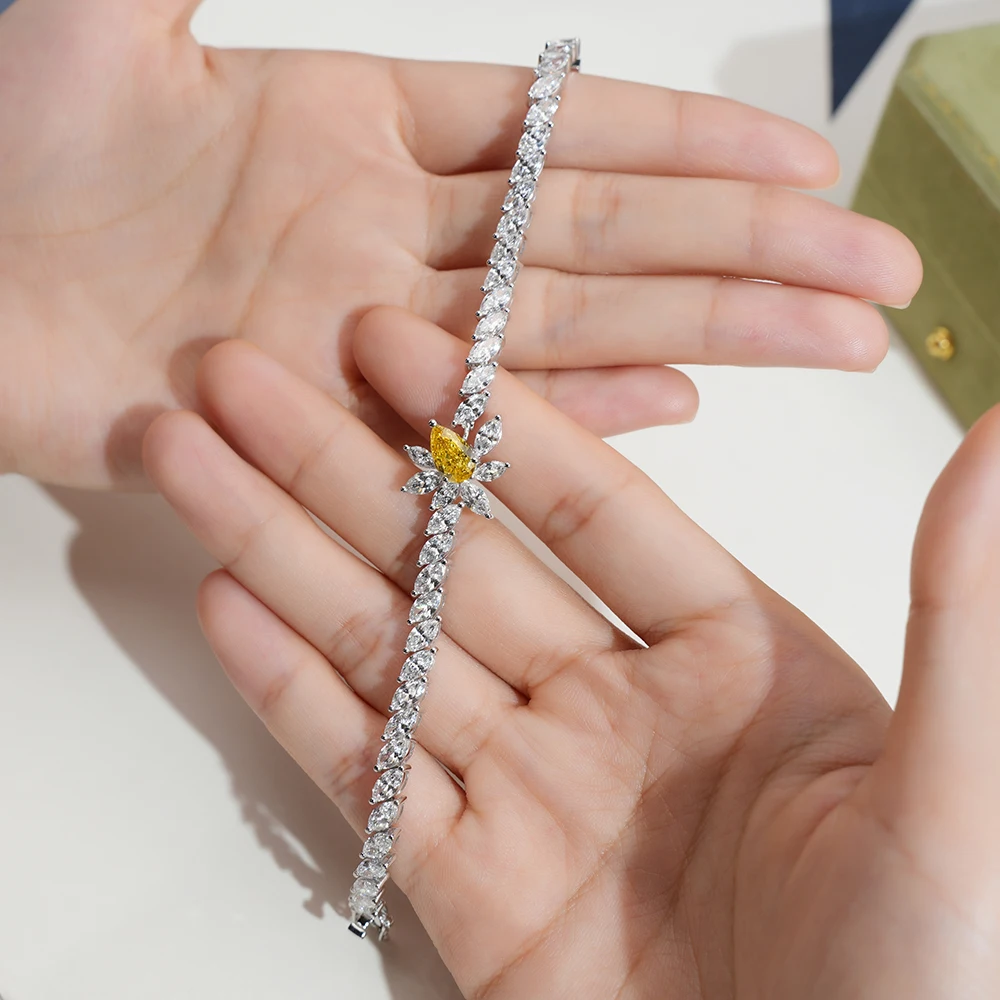 Pear shape lab diamond bracelet held in hands, 18K gold setting, star cluster design – Vexaro