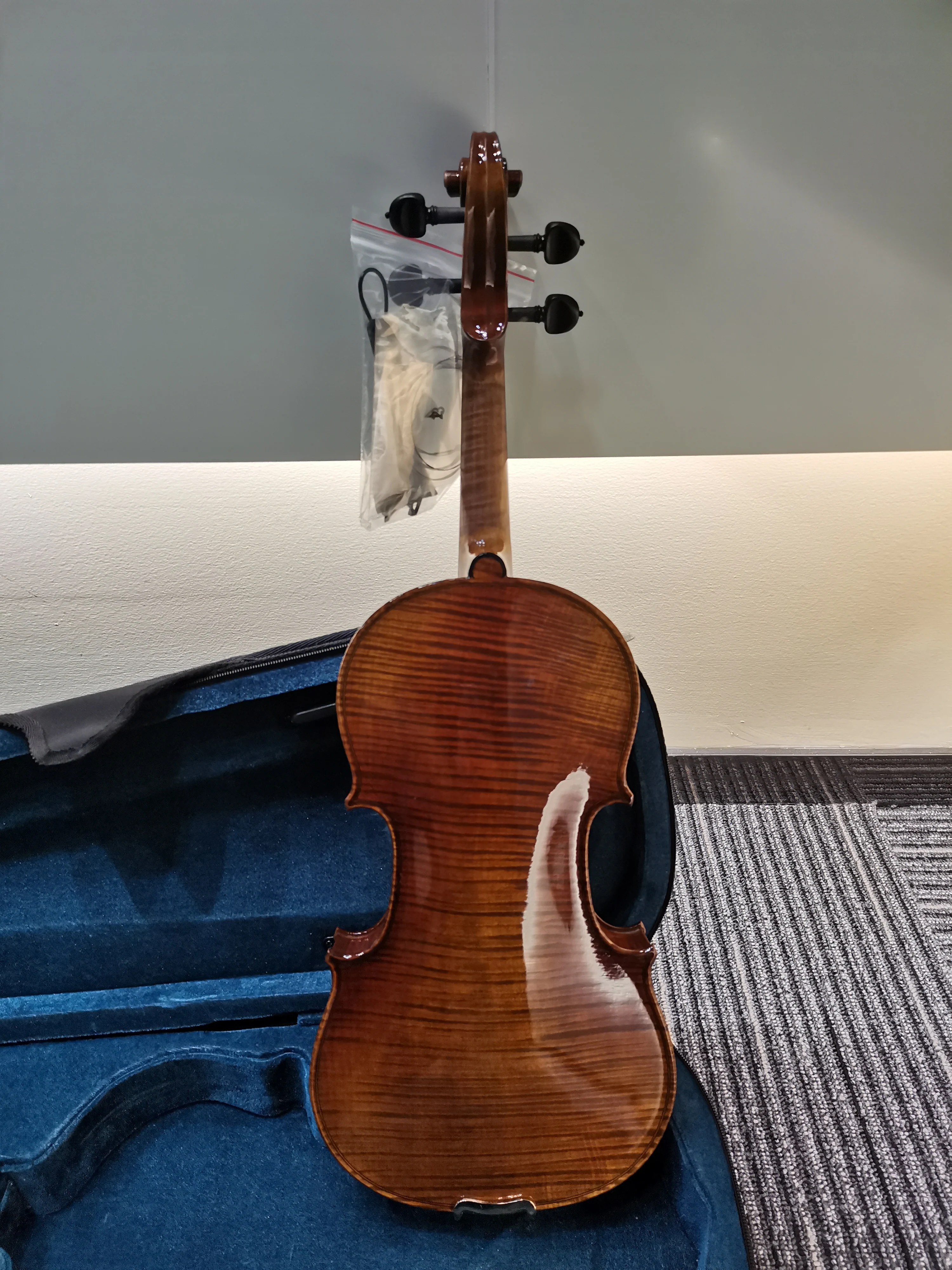 4/4 high-end handmade Italian violin with ebony flat knobs and vintage lacquer, featuring strings, bow, and case.