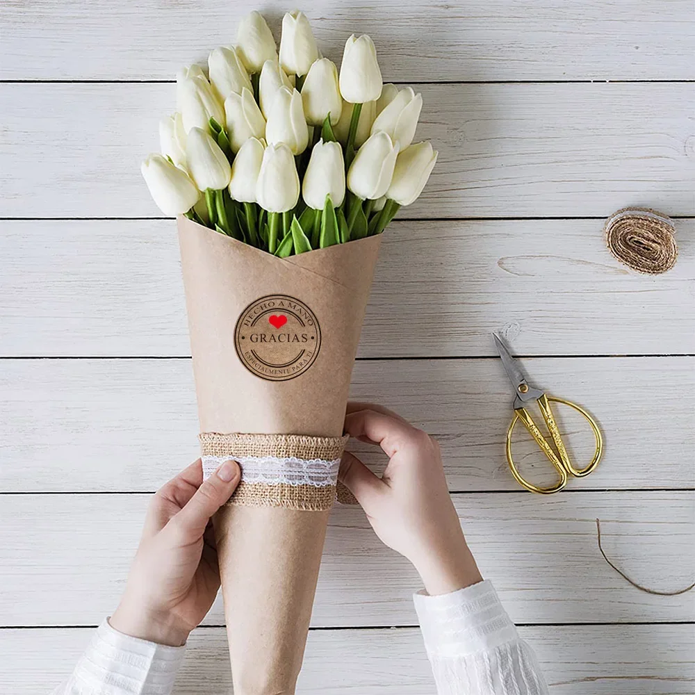 Hand peeling a kraft thank you sticker from the roll