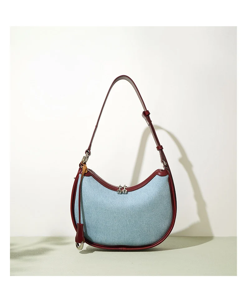 Half moon shoulder bag made of denim with genuine leather trim – casual and stylish design for daily use.