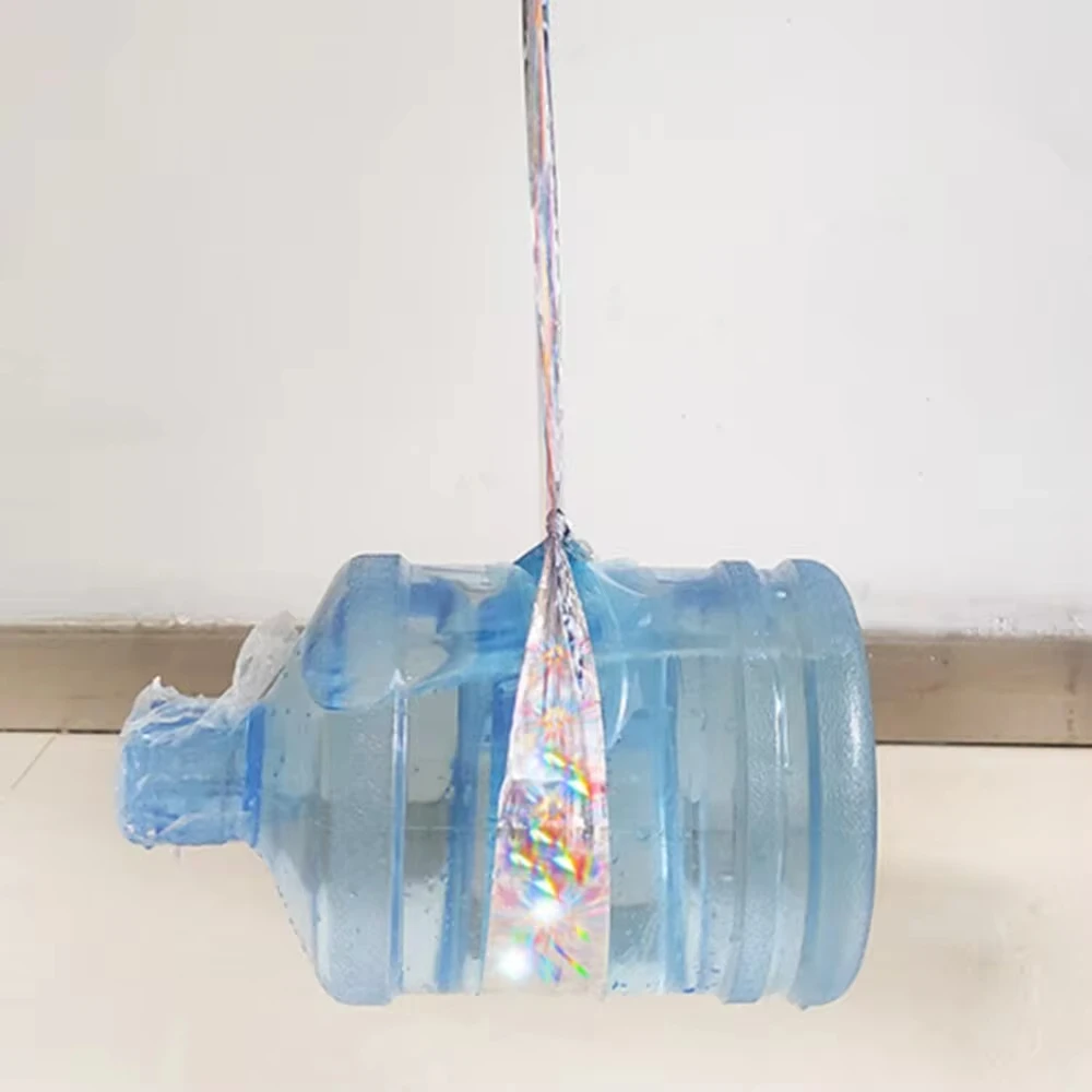 Oiseau s'éloignant d'un arbre décoré de ruban réfléchissant, solution visuelle et sonore contre les nuisibles.
