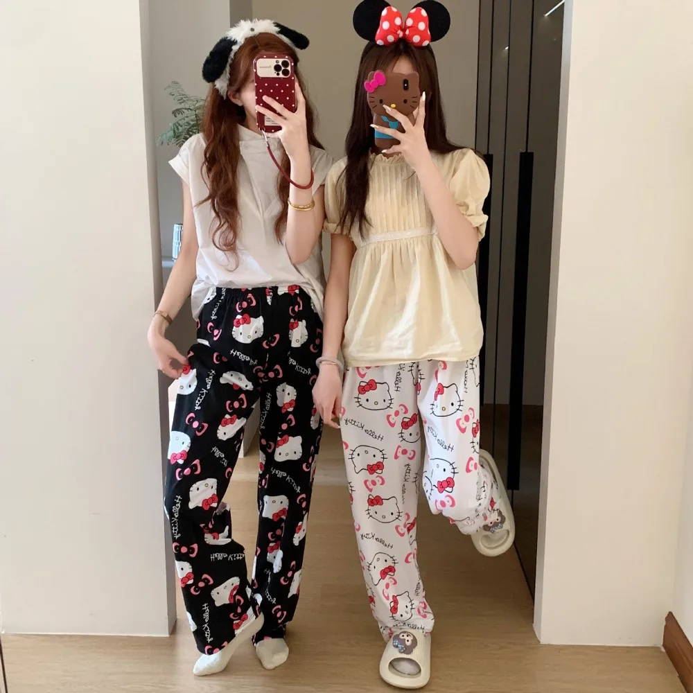 A pair of loose-fitting Hello Kitty pajama pants with a charming cartoon print black and white
