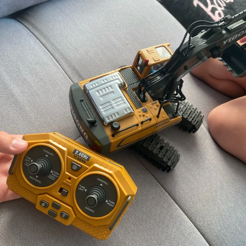 Enfant utilisant la télécommande pour diriger le Tank Robot RC 1B - Voiture Télécommandée Engin de Chantier pour Enfants sur un sol accidenté.