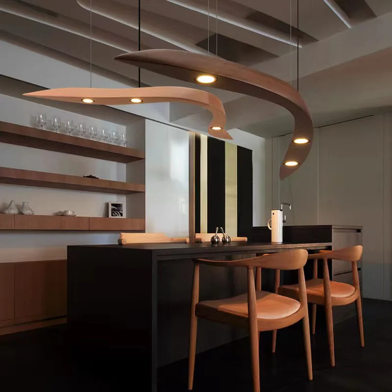 Modern kitchen with a black island, wooden chairs, minimalist shelves, and two Spiral Wood Pendant Lights over the dining area for an organic modern lighting touch.