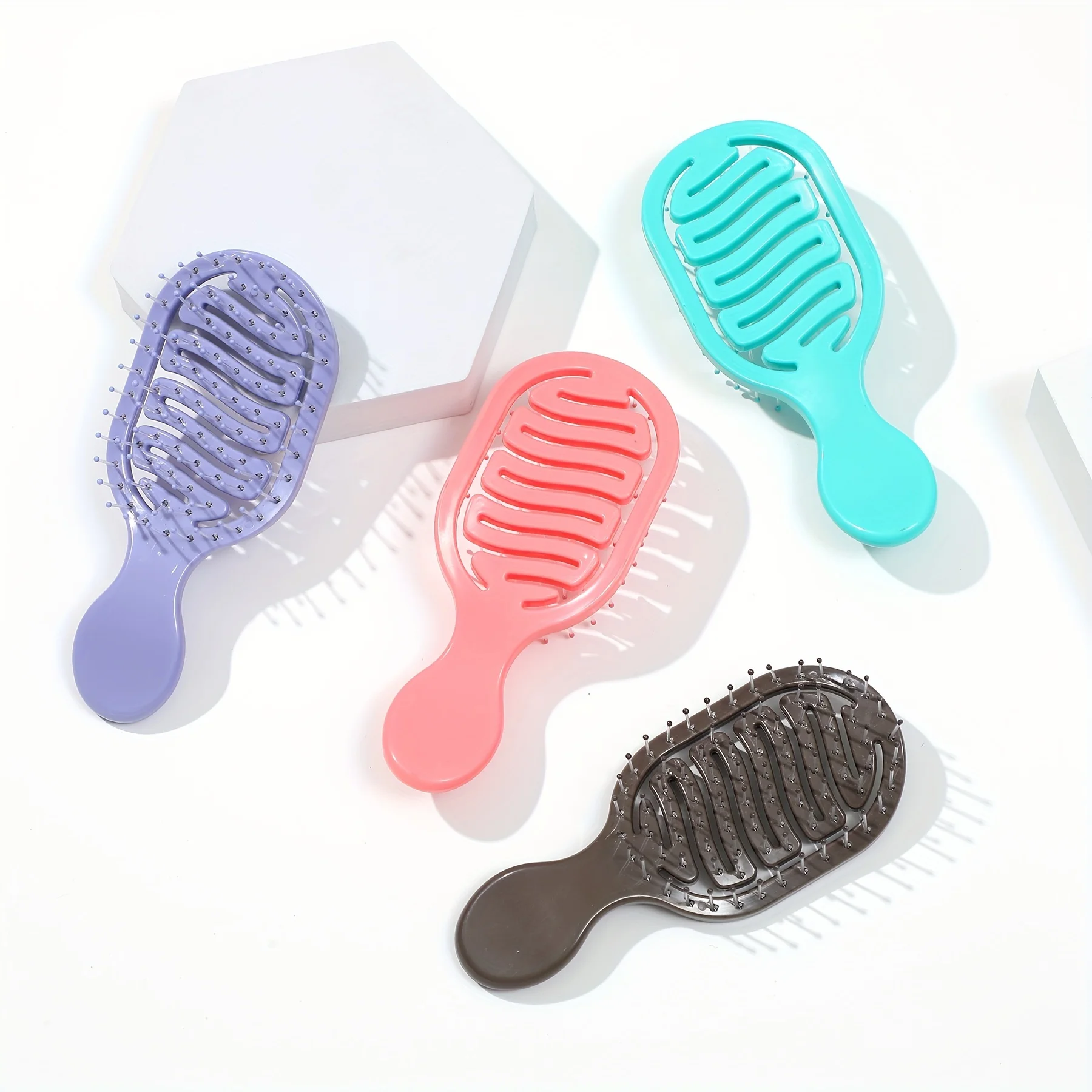 Mini Track Hairbrush, portable hollow design with nylon bristles, ergonomic handle, compact and lightweight—a travel essential.