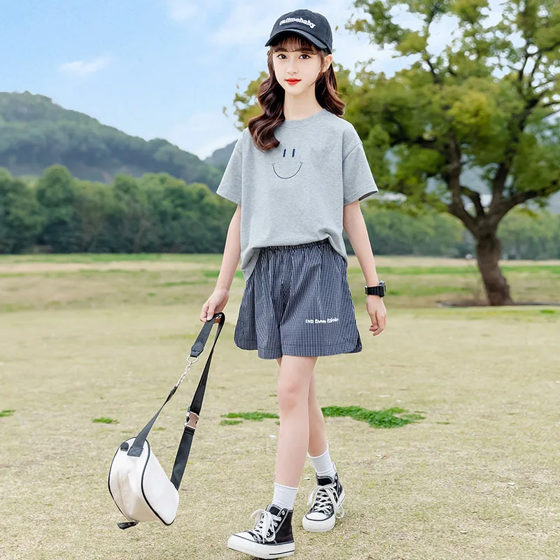 

Корейский Летний комплект детской одежды из 2 предметов для девочек, футболка с принтом улыбающегося лица для маленьких девочек + клетчатые шорты, спортивный костюм для школьниц, 2024