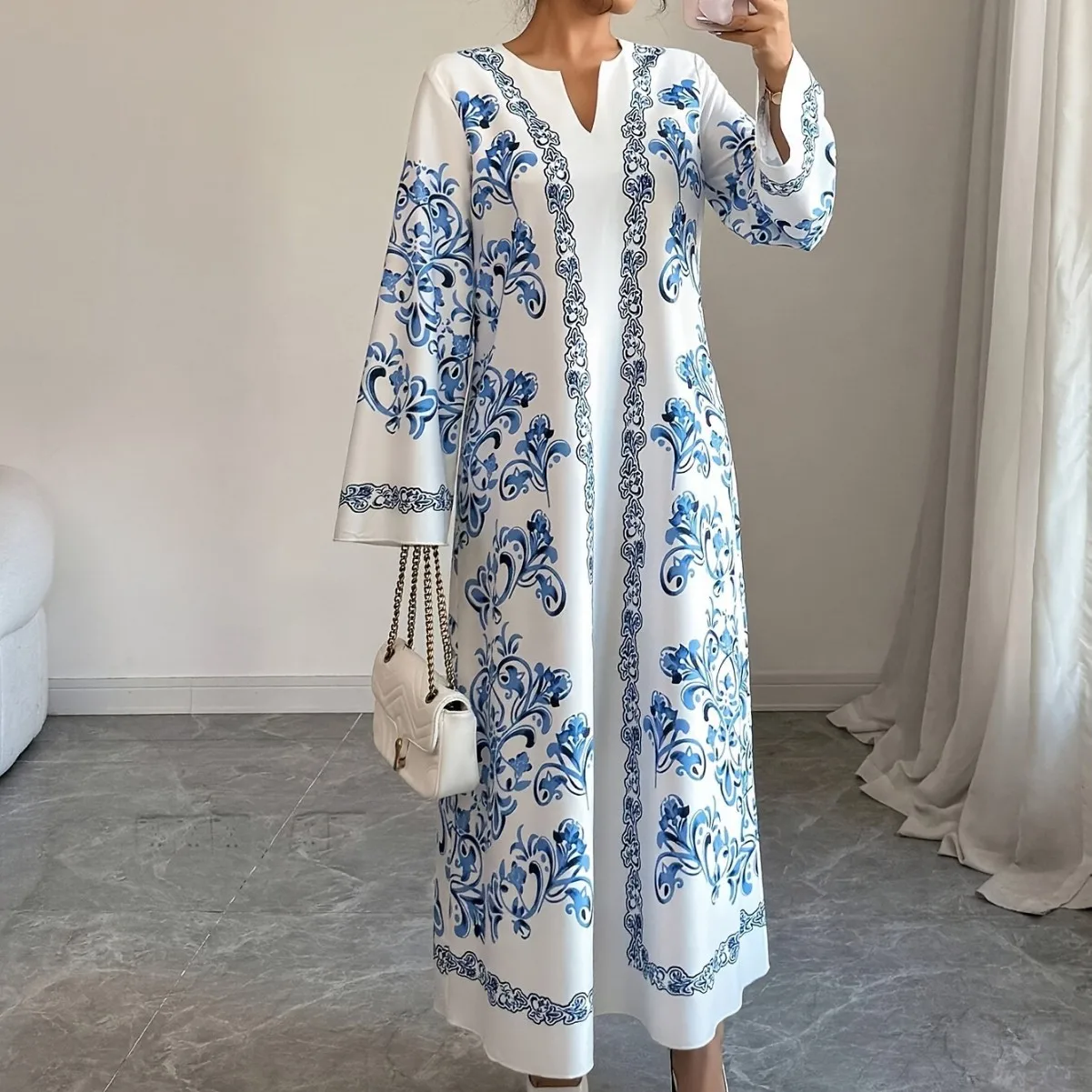 جلابية بيضاء طويلة بنقوش زرقاء وأكمام واسعة