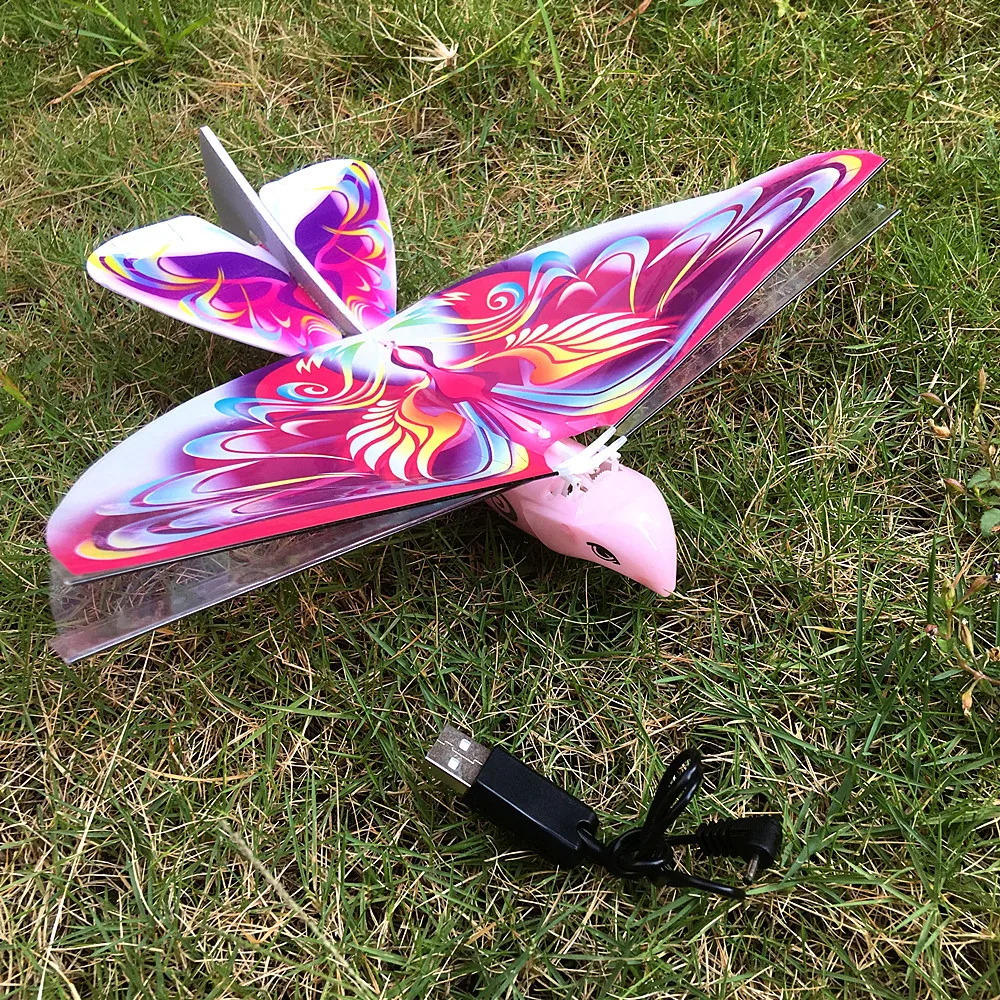 Gros plan sur le drone oiseau en mousse légère, ailes déployées, LED intégrées, design réaliste.