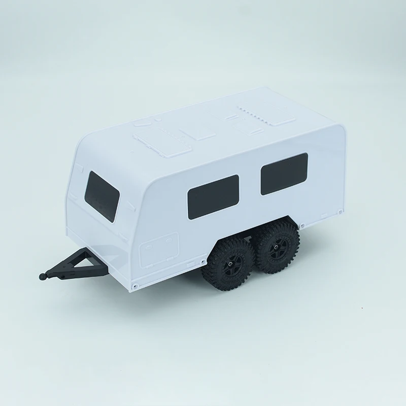Remorque camping-car RC 1/18 pour crawler TRX4M, posée sur sol herbeux