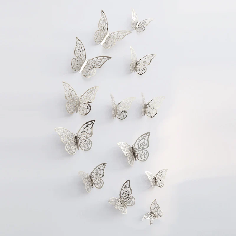 Decorative silver butterflies with intricate cutout designs are arranged in a scattered pattern on a light gray background.
