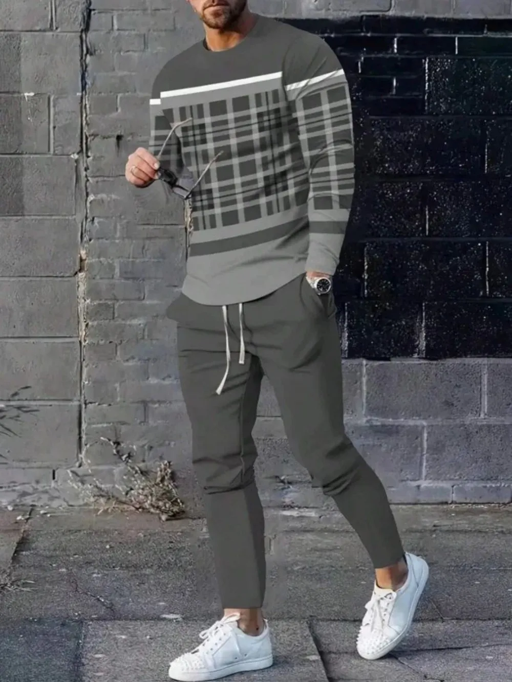 Man wearing striped patchwork long sleeve top and pants set in a sunny outdoor setting dark gray