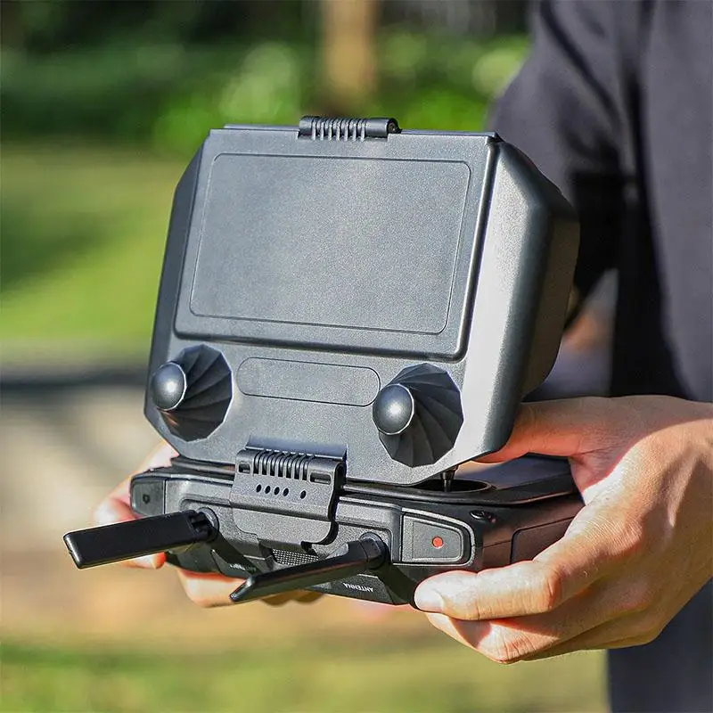 Vue de côté du pare-soleil 2 en 1 pour télécommande DJI, avec un drone en arrière-plan.