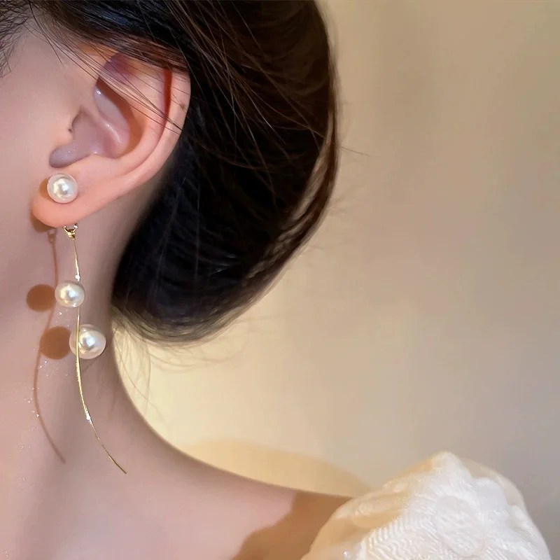 Long tassel pearl dangle earrings displayed against a neutral background