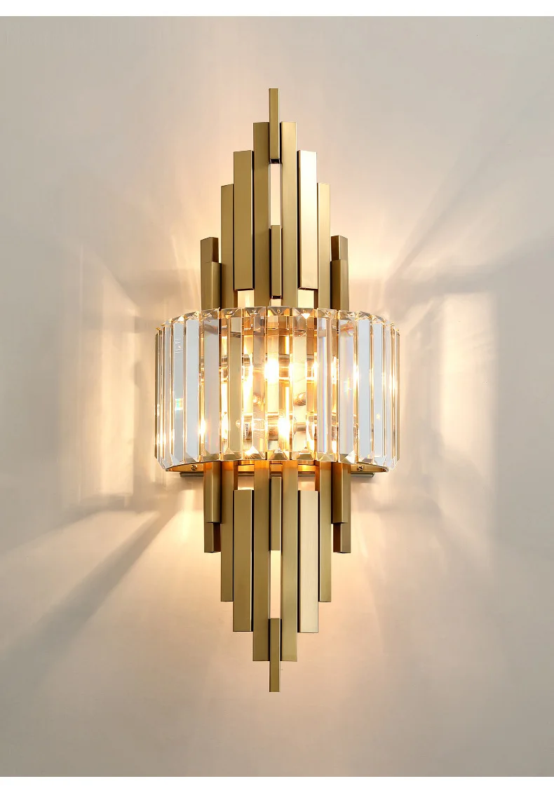 The Luxury Geometric Wall Sconce, featuring a sleek gold and crystal design, serves as a sophisticated home decor piece that casts a warm glow against a light-colored wall.