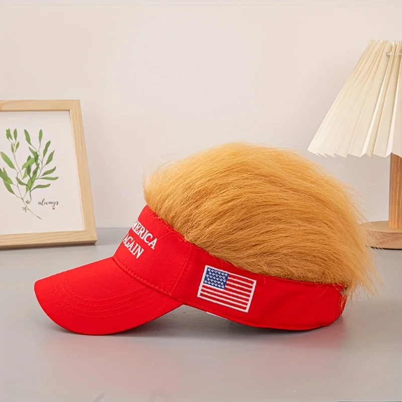 The Visor Cap - Make America Great Again has a red band with the slogan, fake blonde hair on top, and an embroidered American flag patch—making it an eye-catching patriotic conversation starter.