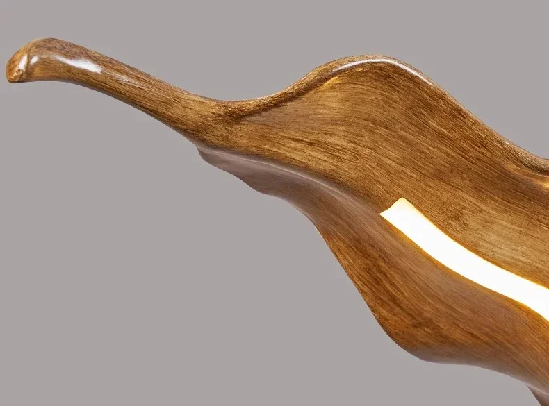 The Drift Wood Pendant Light is a curved, sculpted wooden fixture with an organic-inspired design, a smooth finish, and a light strip embedded in its textured surface.