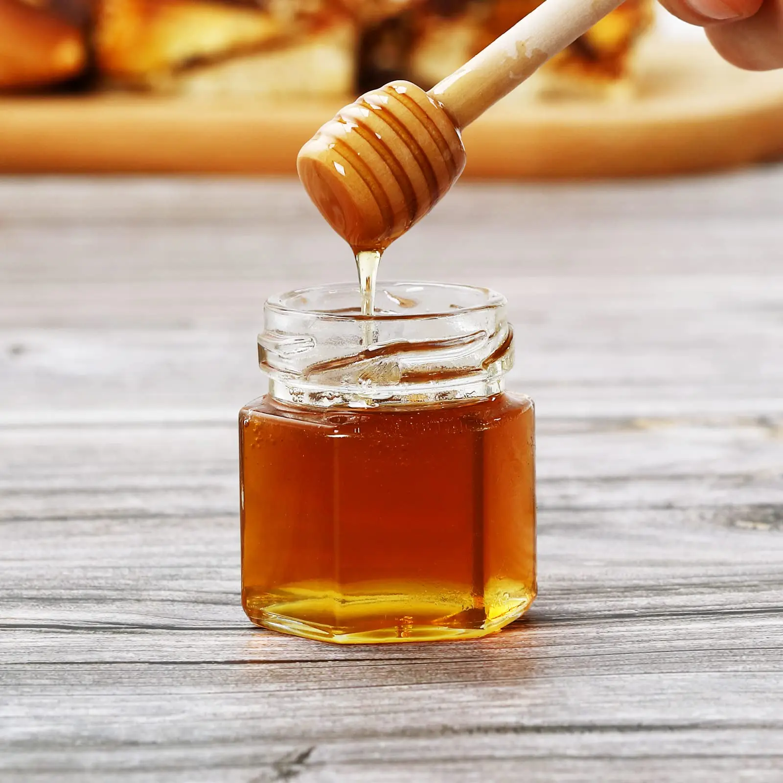 Hexagon mini honey jars with gold lids, wooden dippers, bee charms, and jute twine. Perfect for baby showers, 20-pack.