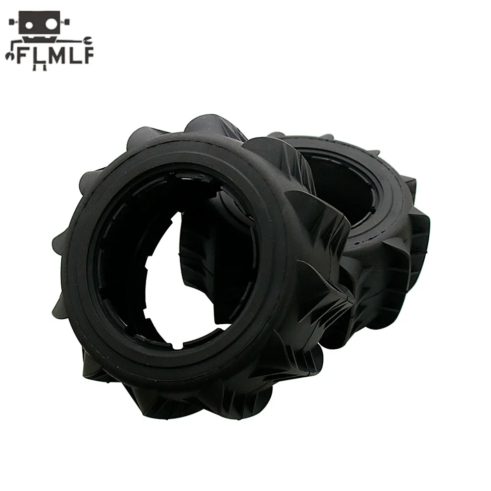 Deux pneus RC tout-terrain 195x90mm posés sur le sable, illustrant leur utilisation sur terrain meuble