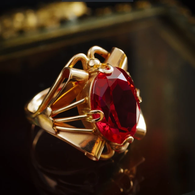 Premium Photo | A gold ring with a red stone and diamonds on it