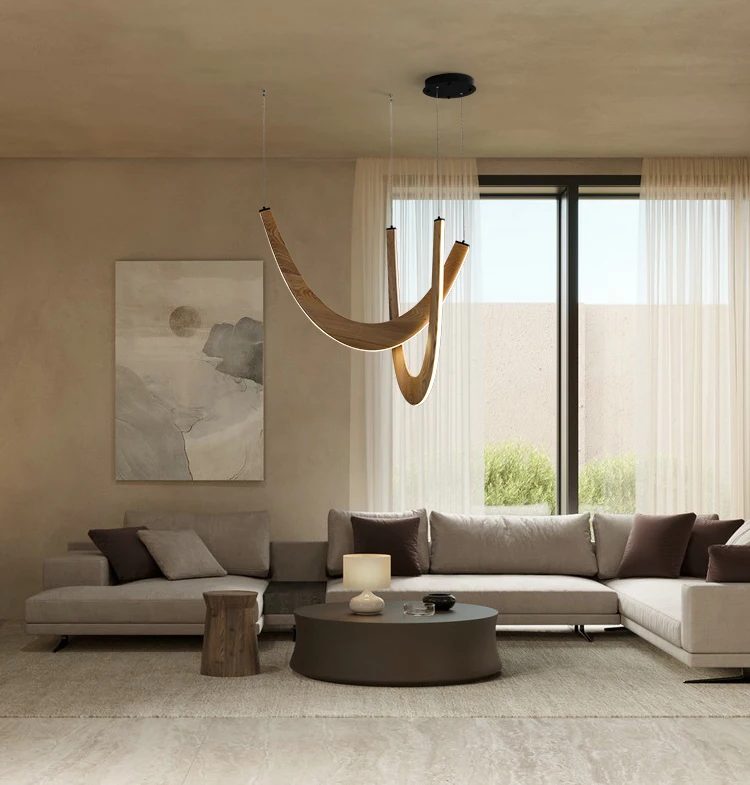 Modern living room with neutral tones, featuring two beige sofas, a circular coffee table, abstract wall art, and the Double Curve Wood Pendant Light serving as a sculptural chandelier hanging from the ceiling.