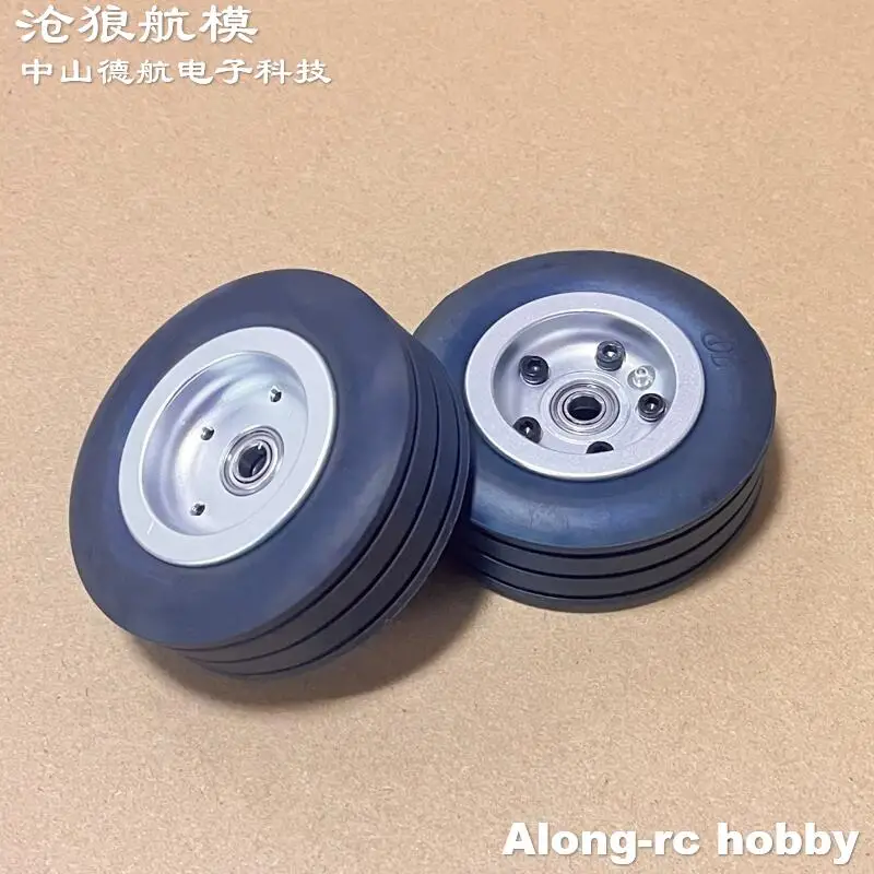 Roues et pneus avion RC 70mm en caoutchouc, gros plan sur le pneu texturé et la jante métallique.