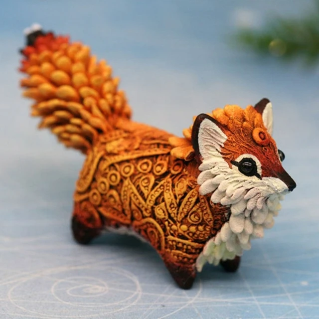 Une Figurine De Renard Avec Un Médaillon Bleu Et Or Sur Le