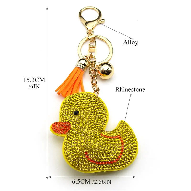 A sparkly yellow rhinestone duck keychain featuring an orange fringe tassel and golden bell displayed on a hand and showcasing metric dimensions