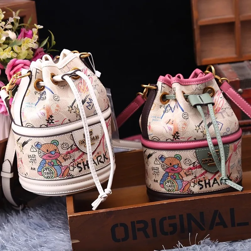 Fashion Brand Cartoon Graffiti Printed Drawstring Bucket Bag with High Texture and Niche Design Women's Handheld Cylindrical Bag