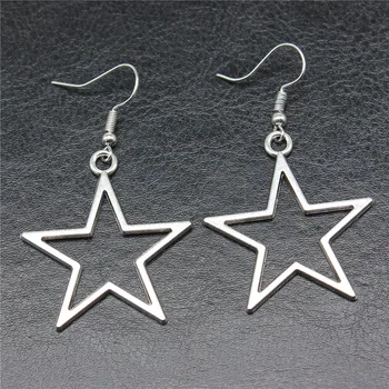 A pair of Hollow Star Pendant Drop Earrings for Women on a black surface.