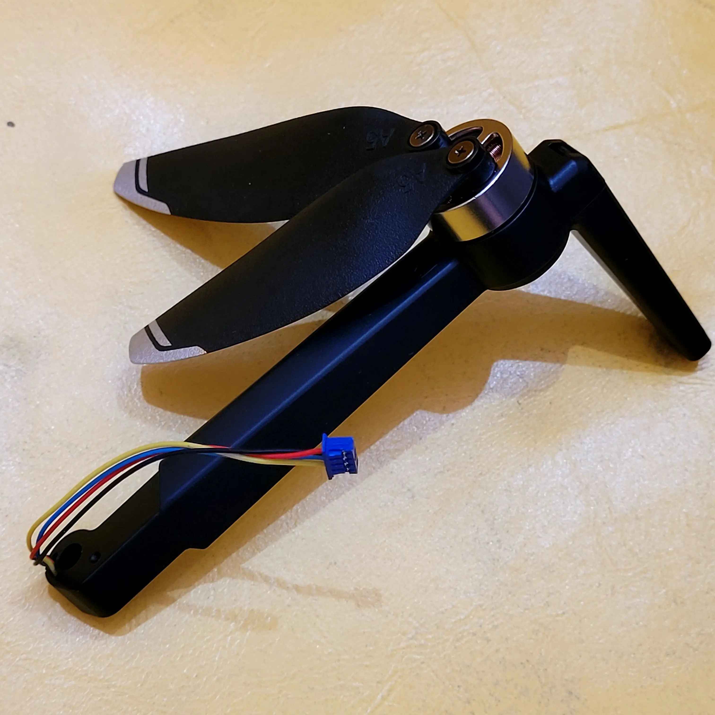 Bras de drone en alliage compatible DJI, gros plan sur l'embout de fixation et la texture métallique.