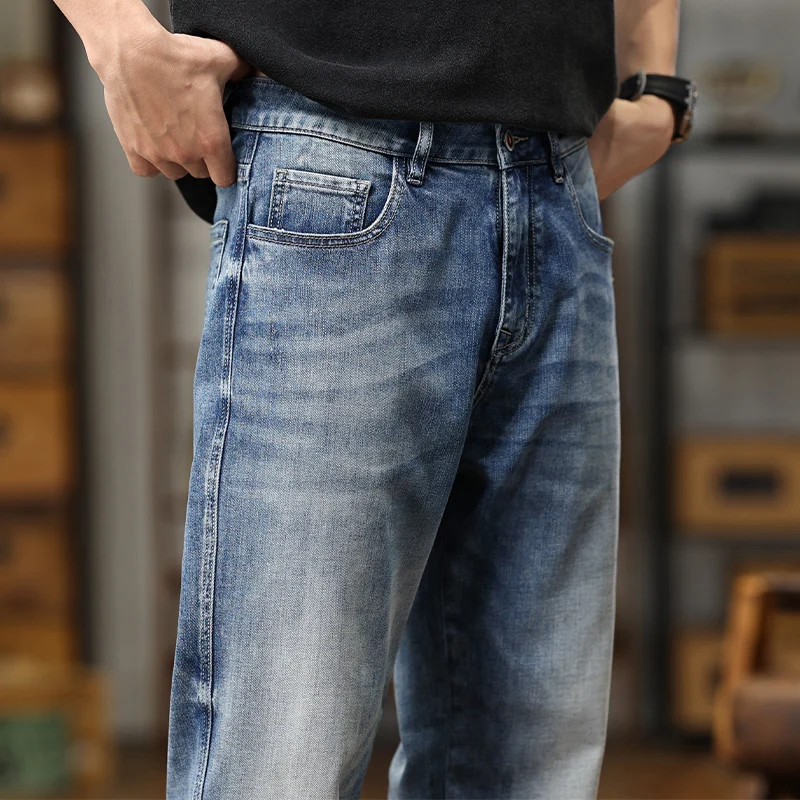 Les jeans amples en denim bleu clair présentent une coupe décontractée à jambe large, avec un style classique à cinq poches, en denim bleu de délavage moyen.