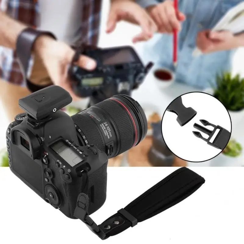 Bracelet main confortable et sécurisé enroulé autour du poignet, avec l'appareil photo pendant librement.