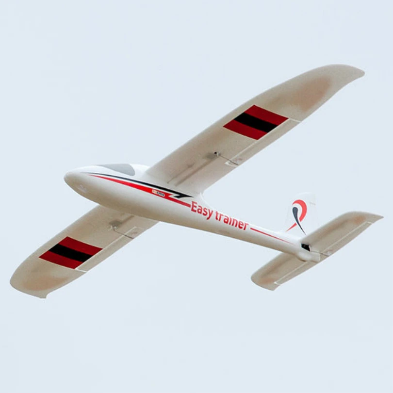 Avion RC planeur entraîneur FPV en vol, avec moteur poussoir visible sous l'aile