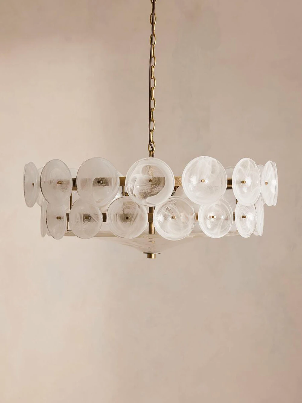 The Italian Retro Pendant Light features frosted circular glass discs and a brass chain, hanging against a simple beige background, showcasing its modern mid-century style.