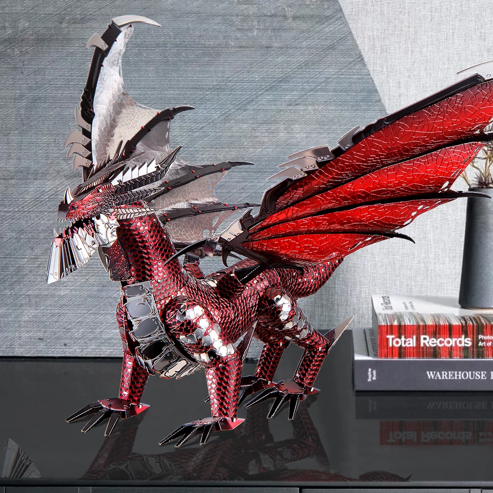 De rode metalen draak op een donker bureau naast boeken