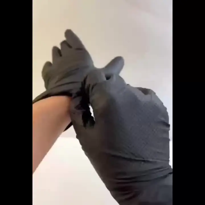 Gants jetables Diamond Black enfilés sur des mains, utilisation professionnelle.