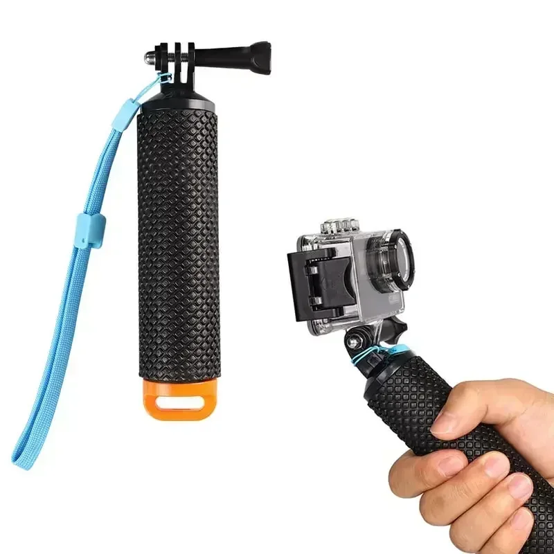 Main tenant une poignée flottante orange et bleue avec une caméra action fixée, prête pour le snorkeling.
