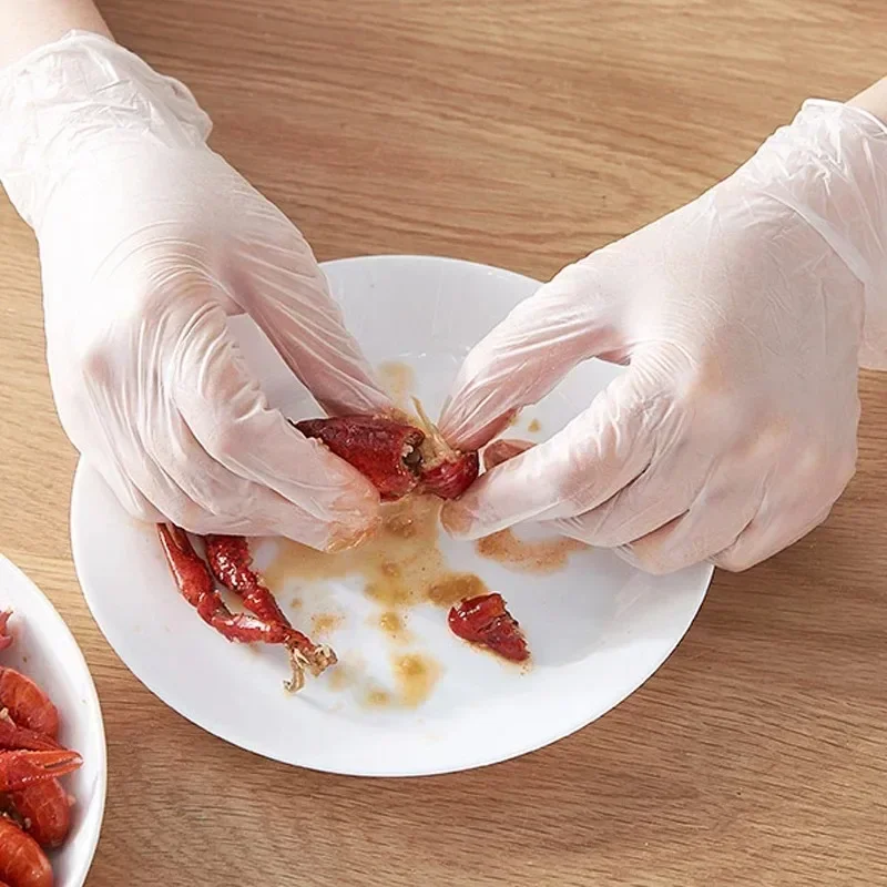 Gants TPE jetables transparents lot de 100, qualité alimentaire, empilés sur fond blanc.