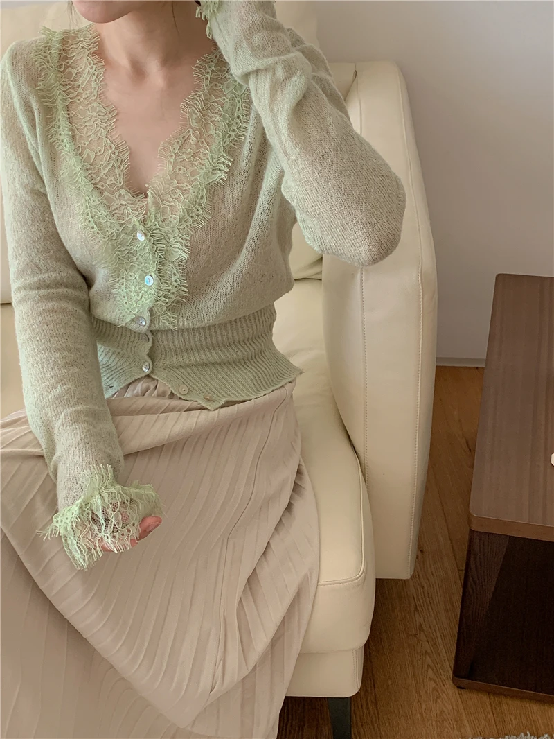 Detailed view of the single breasted button front and floral embroidery on the knit sweater.