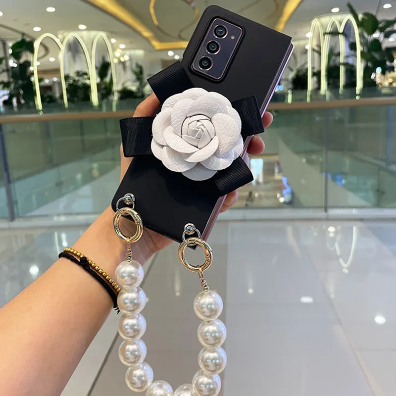 Per Samsung Galaxy Z Fold 5 4 3 2 5G Luxury Fashion Camelia Flower Portable Big Pearl Hand Chain Black Matte Skin Case Cover