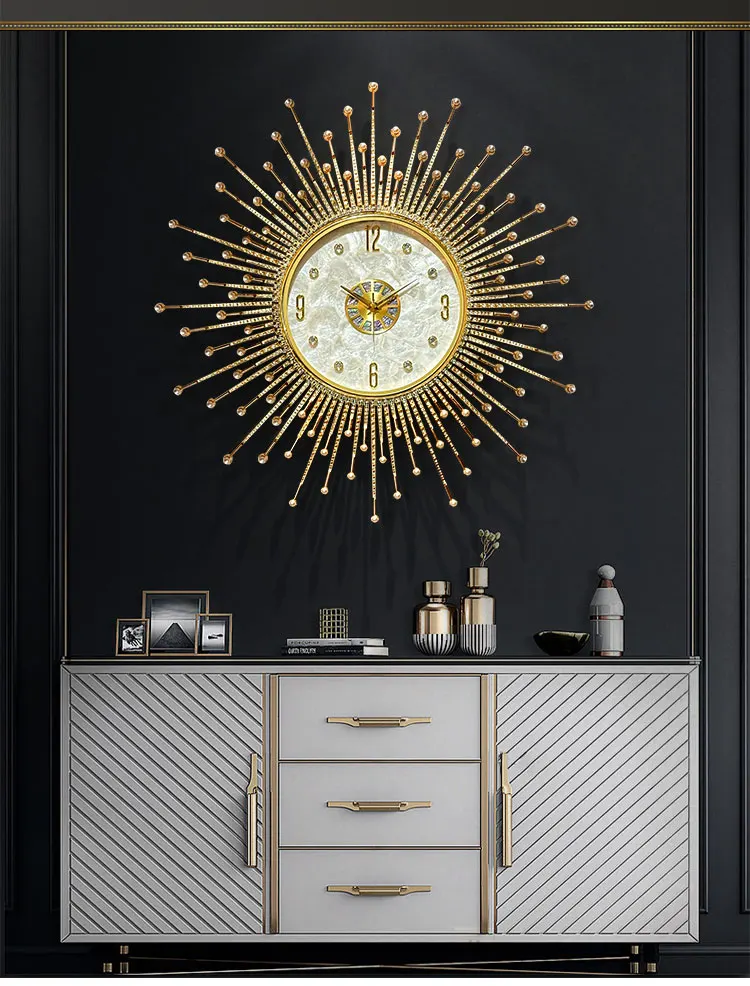Premium Sun Wall Clock hangs above a modern sideboard with gold accents, framed photos, and decorative items, all set against a dark wall.