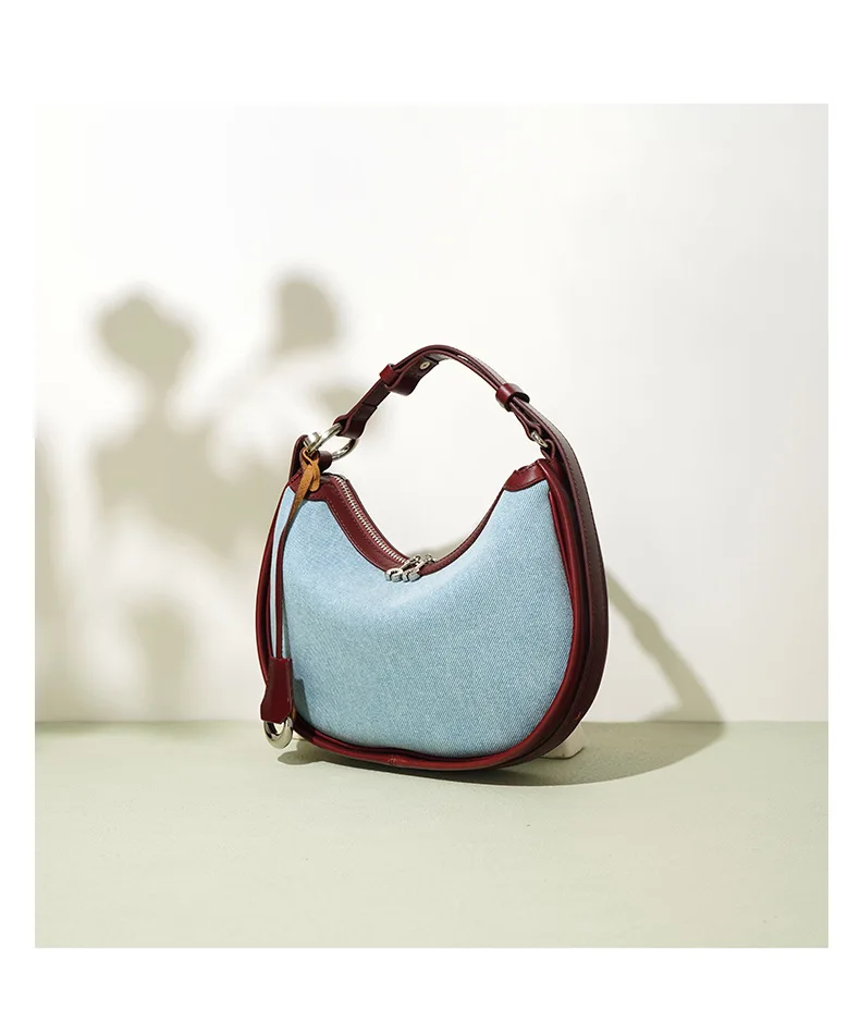 Half moon shoulder bag made of denim with genuine leather trim – casual and stylish design for daily use.