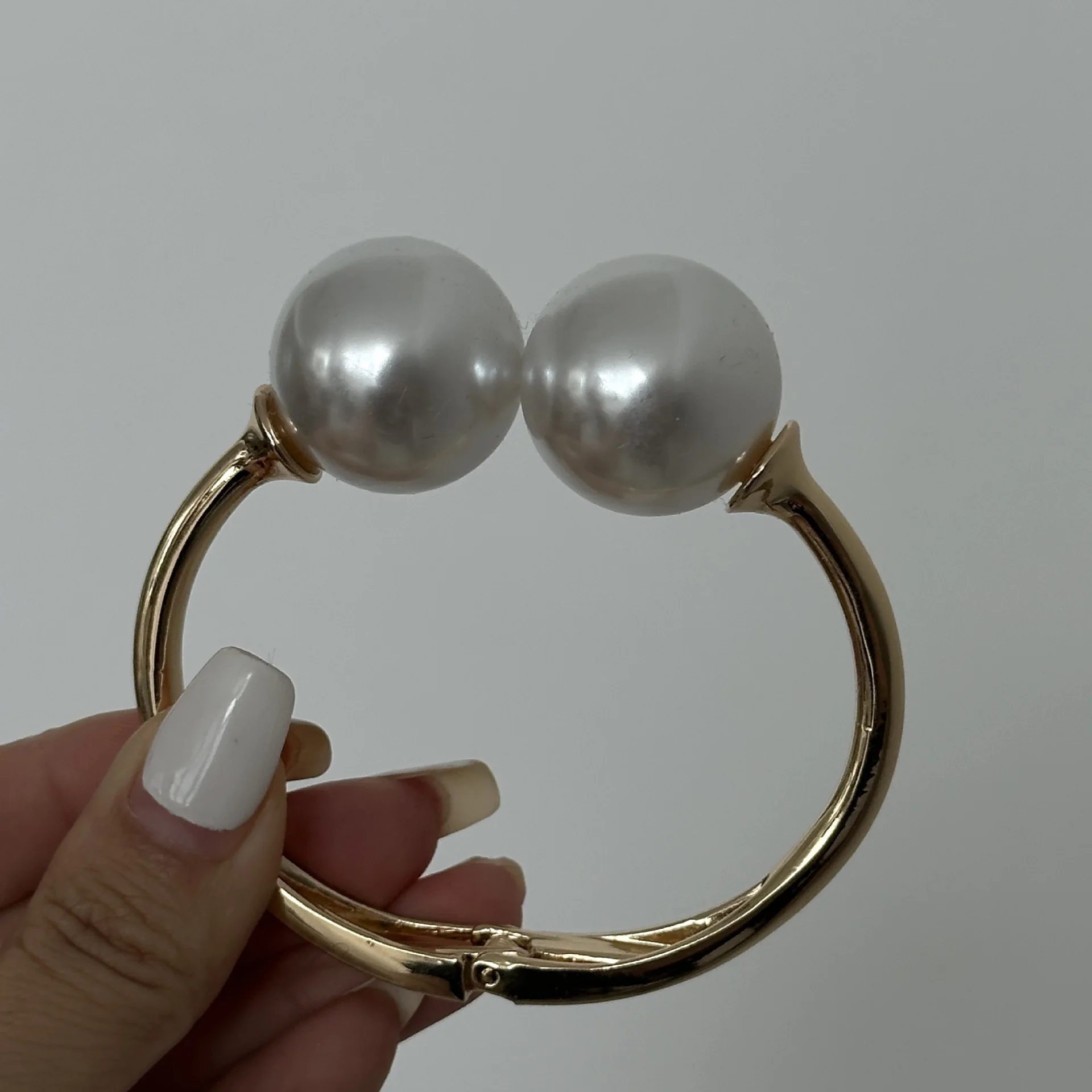 Gold-tone cuff bracelet with pearl ends for women – wide statement bangle with modern fashion appeal.