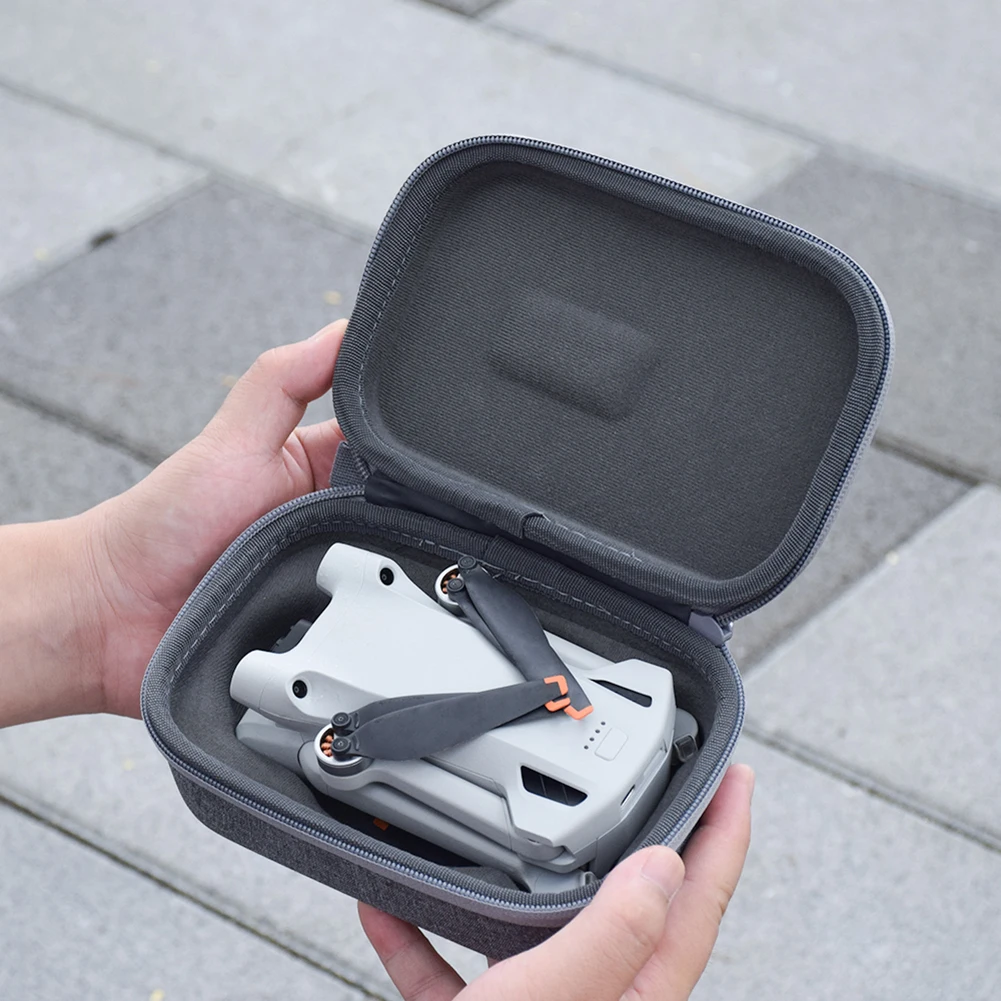 Sac de transport pour DJI Mini 3 Pro avec étui de rangement et télécommande, posé sur une table.