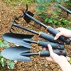 Durable metal gardening trowel with ergonomic black handle and orange decoration - perfect for planting flowers and vegetables. 2